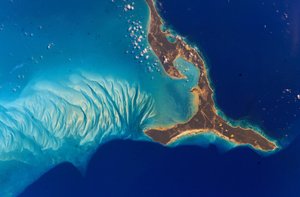 島の西にあるエリューセラ島、2002年。島の西側の水中層は、サンゴ礁から浸食され、海流によって砂丘に堆積した炭酸カルシウム砂でできています。 NASAの信用。サイエンスE